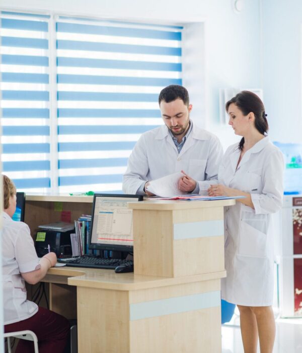 Busy reception in a hospital with doctors and receptionists.